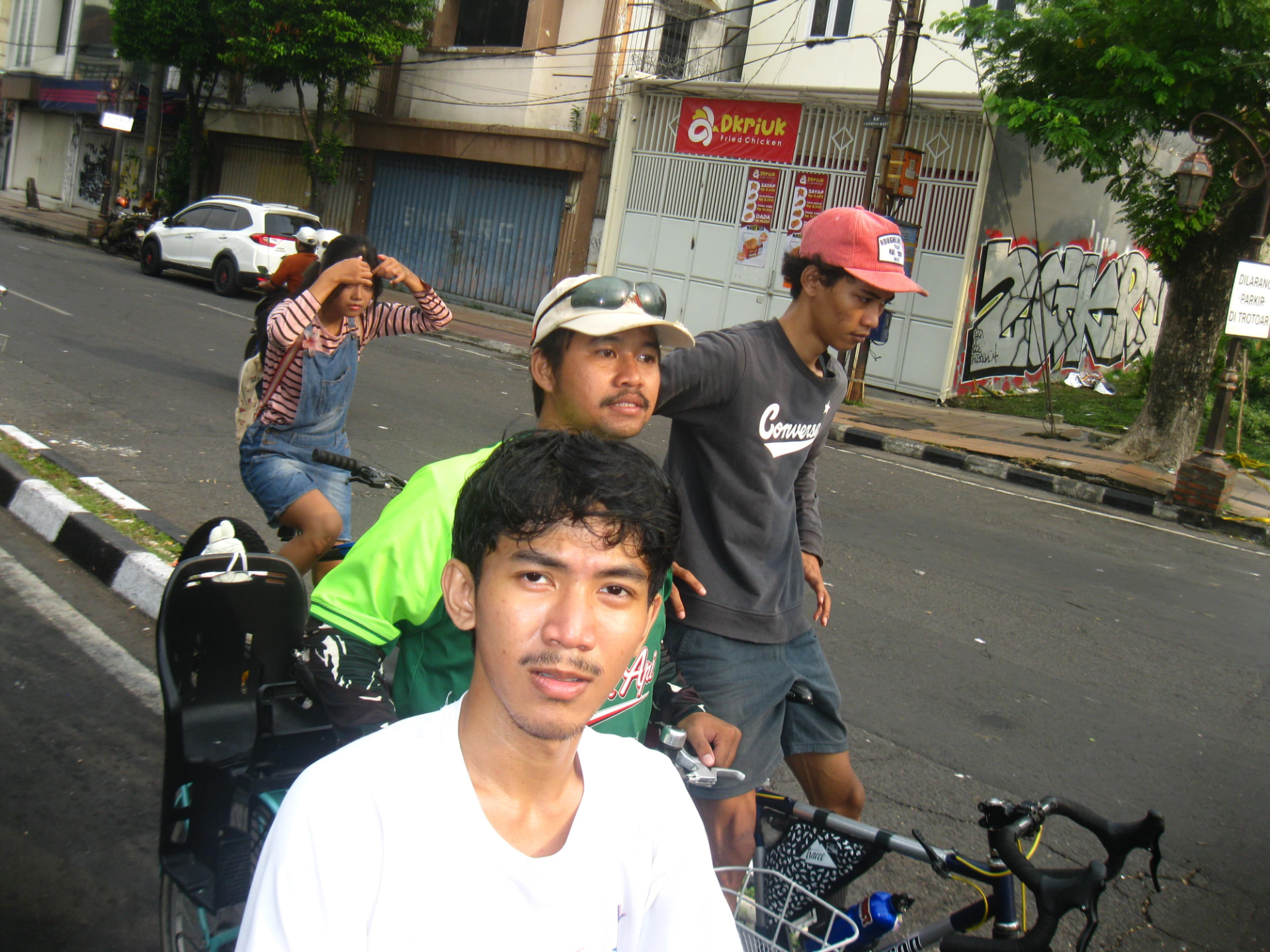 Riders on a Surabaya street in the morning light